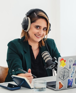 Ari mit Kopfhörern am Podcast-Mikrofon