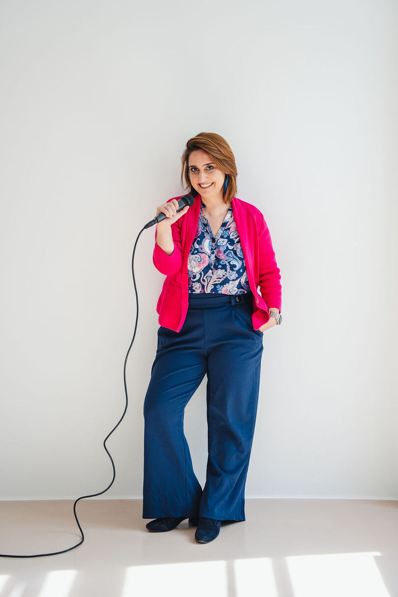 Ari im pinken Blazer mit Mikrofon